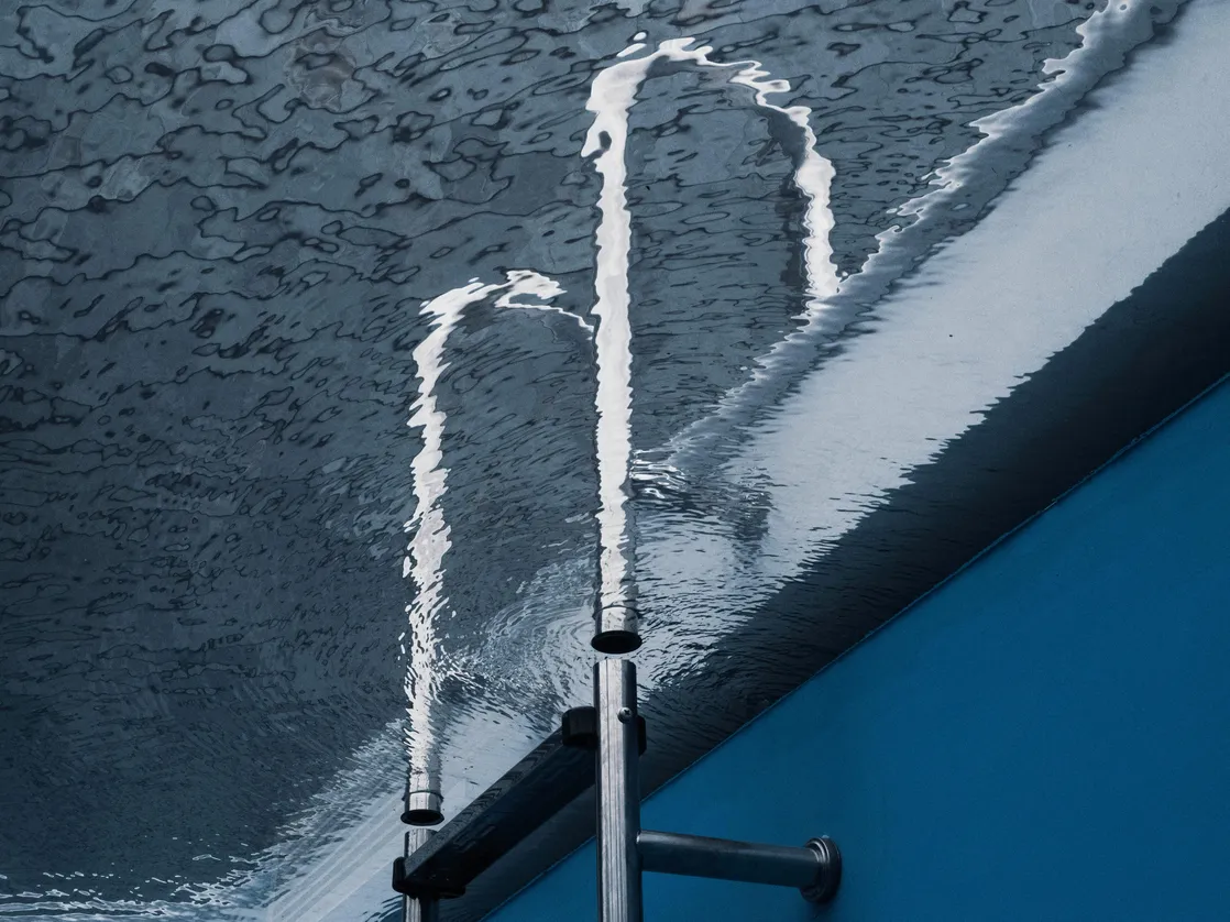 Water from pool algaecide treatment flowing into a swimming pool