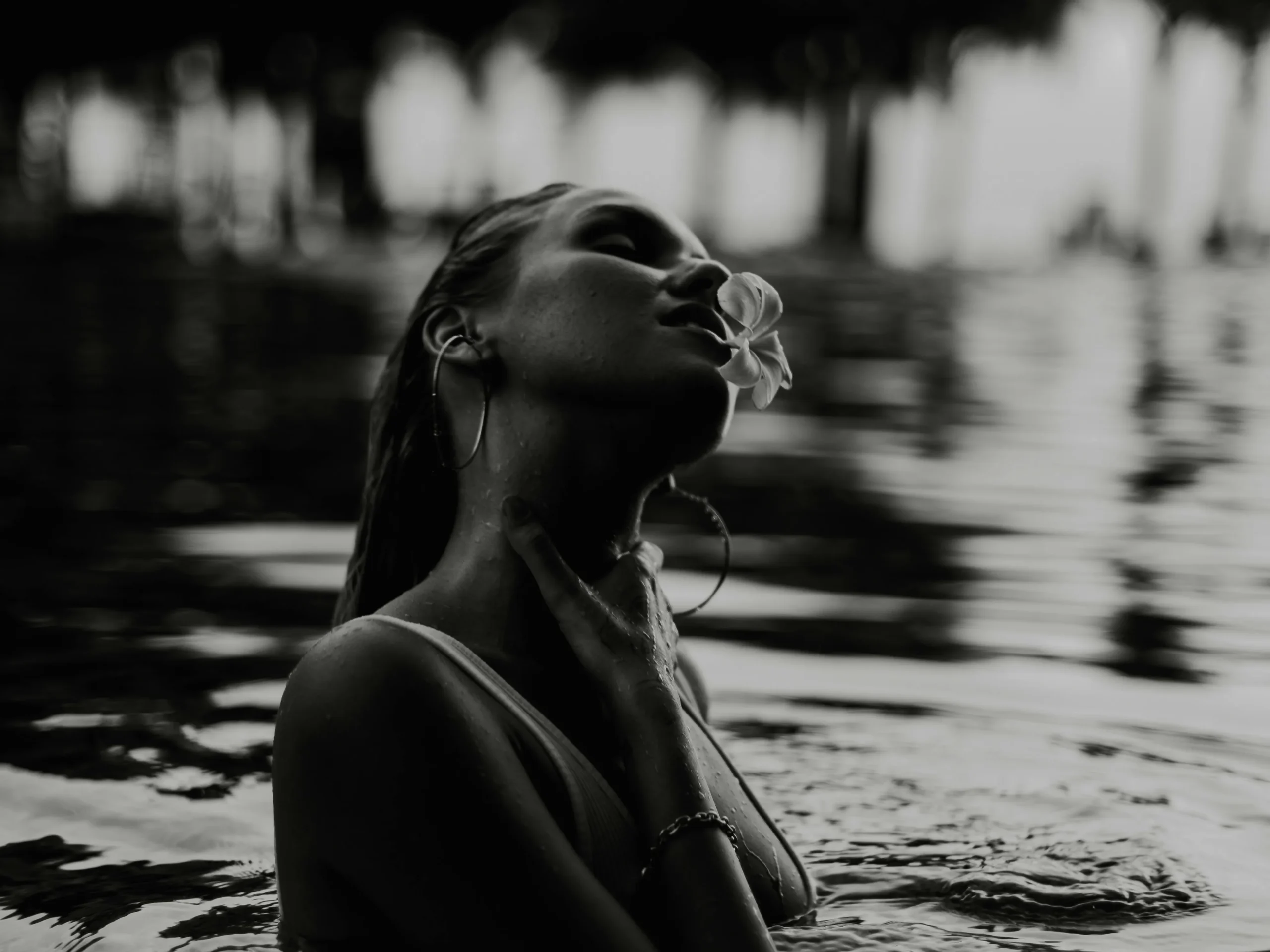 Woman enjoying a dip in a pool, illustrating the benefits of using a black pool cover to heat water.