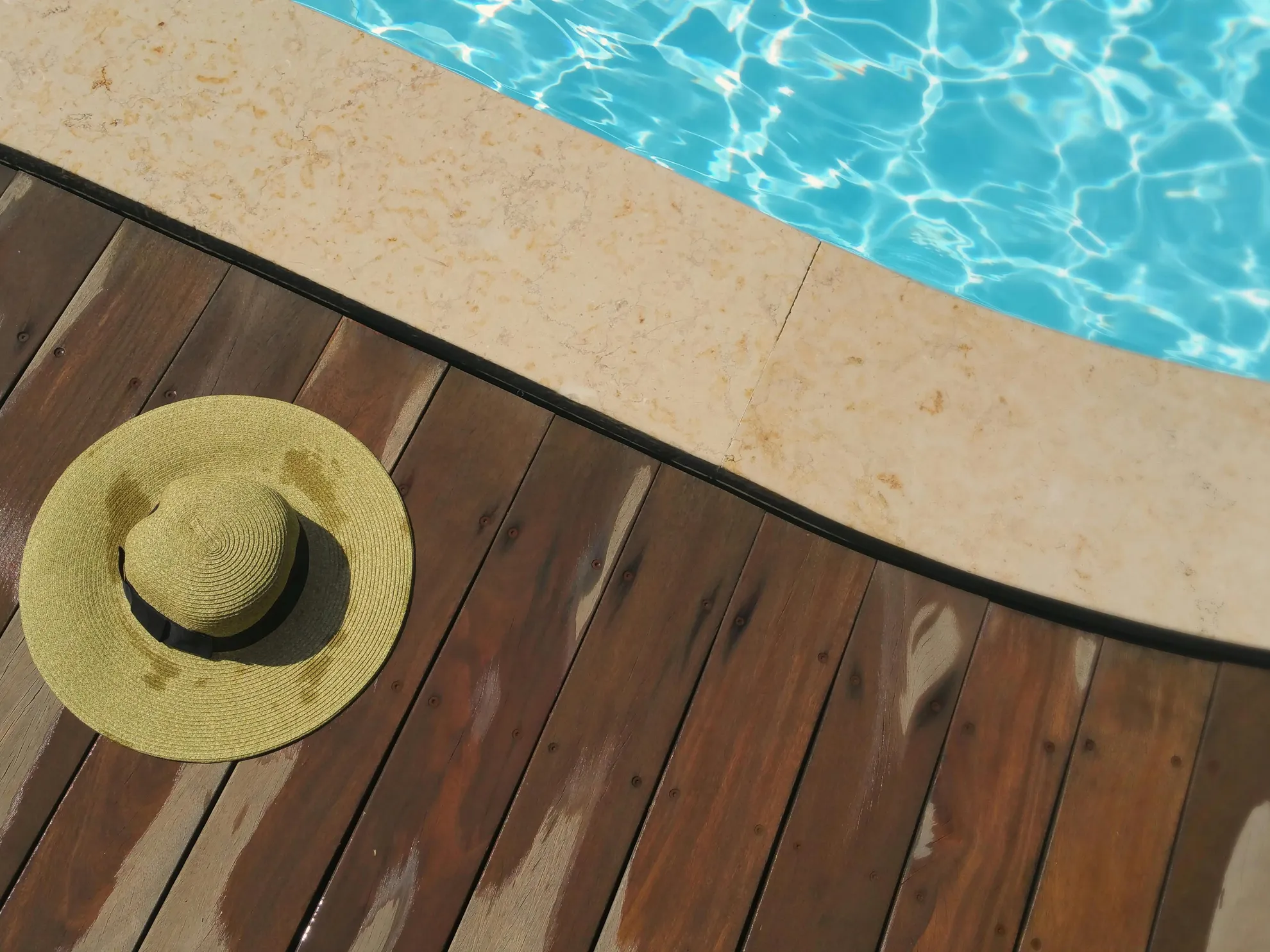 A concrete pool with a sun hat on the deck, highlighting whether concrete pools have liners.