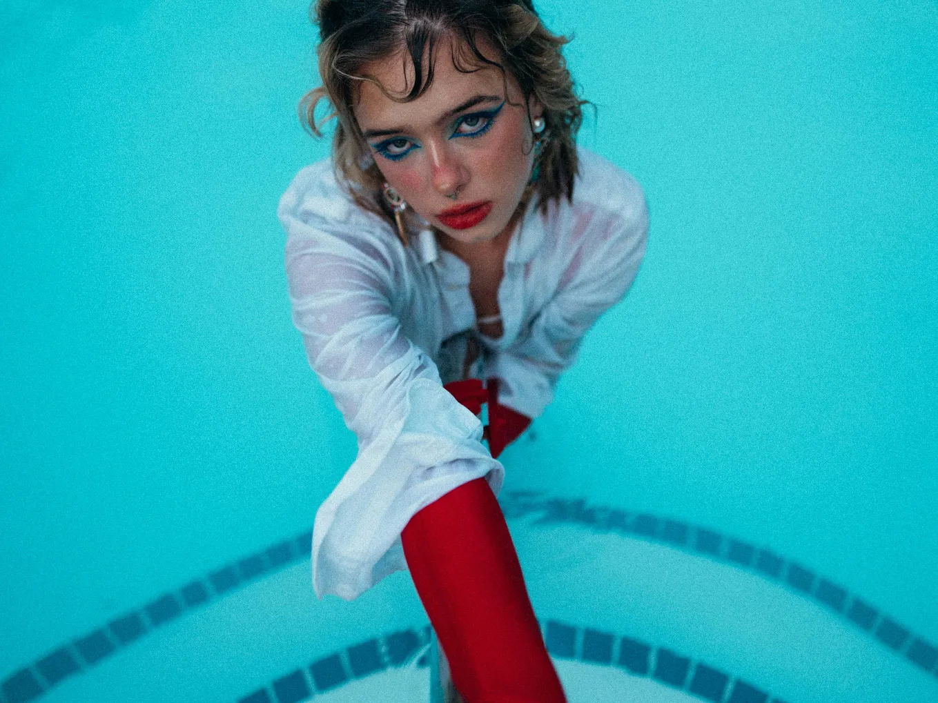 A woman in a pool demonstrating the maintenance of fiberglass pools for draining and saltwater compatibility