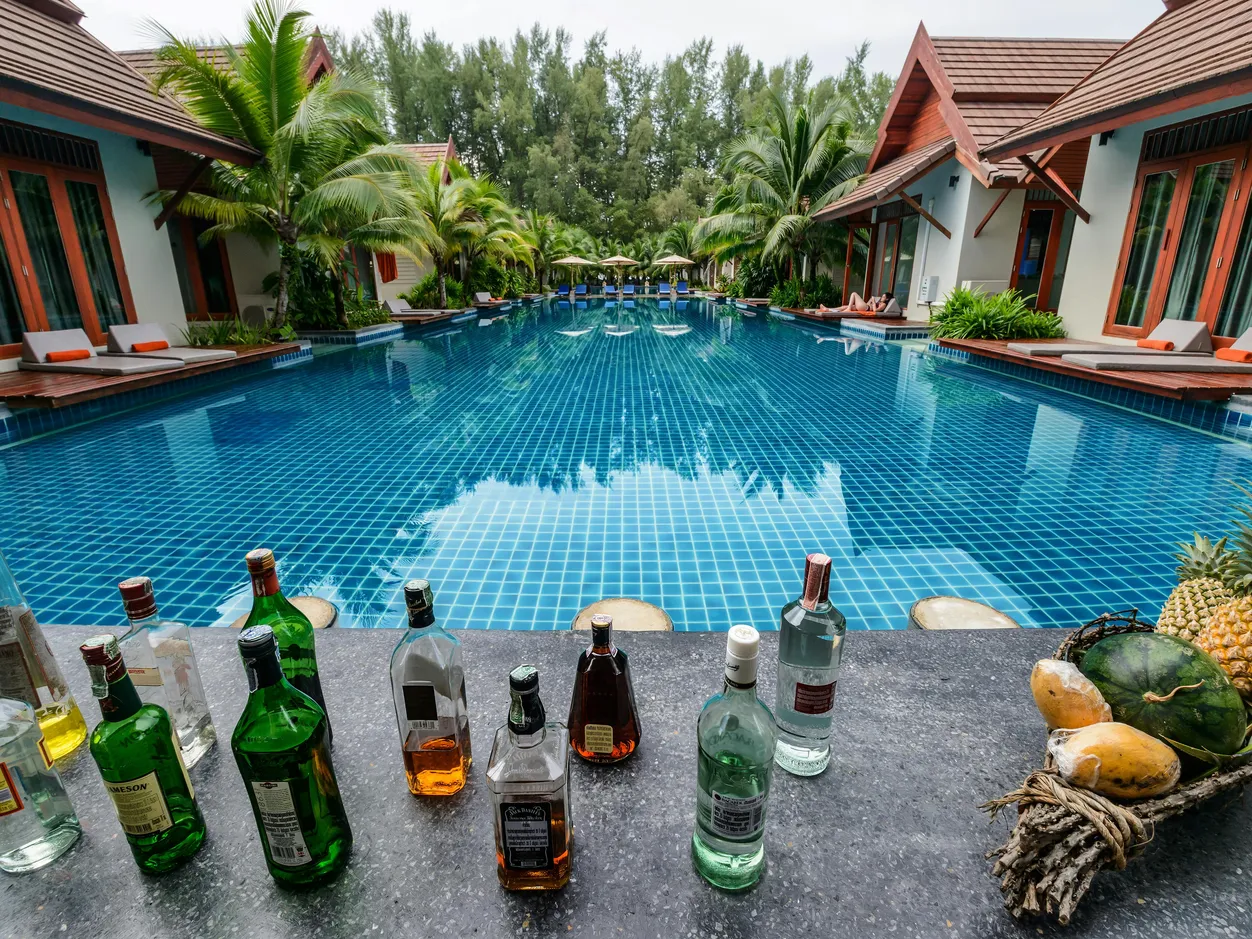 Beautifully painted above ground pool surrounded by palm trees and a patio.