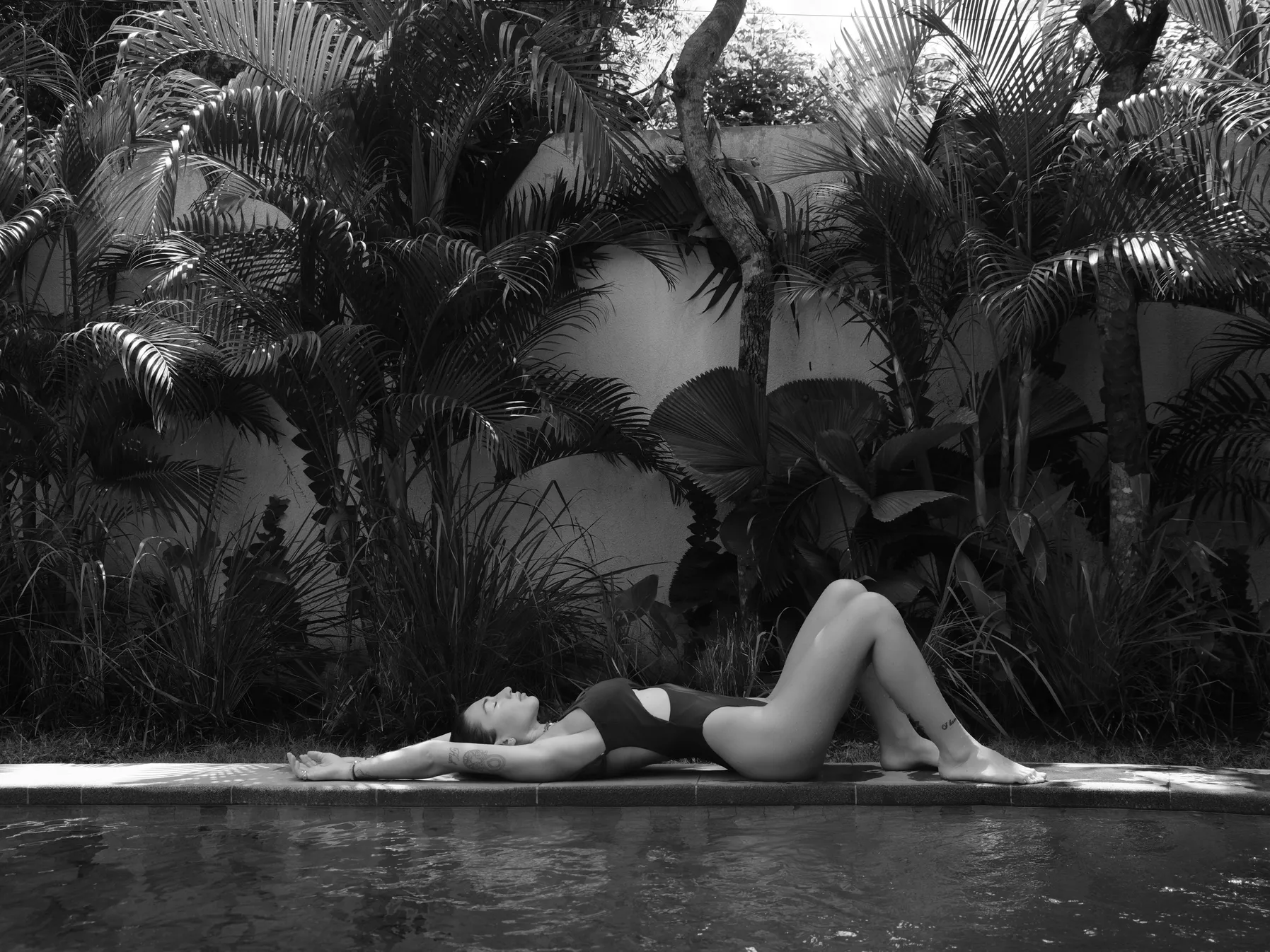 Woman relaxing by the pool while discussing if the pool pump needs to be on for the heater