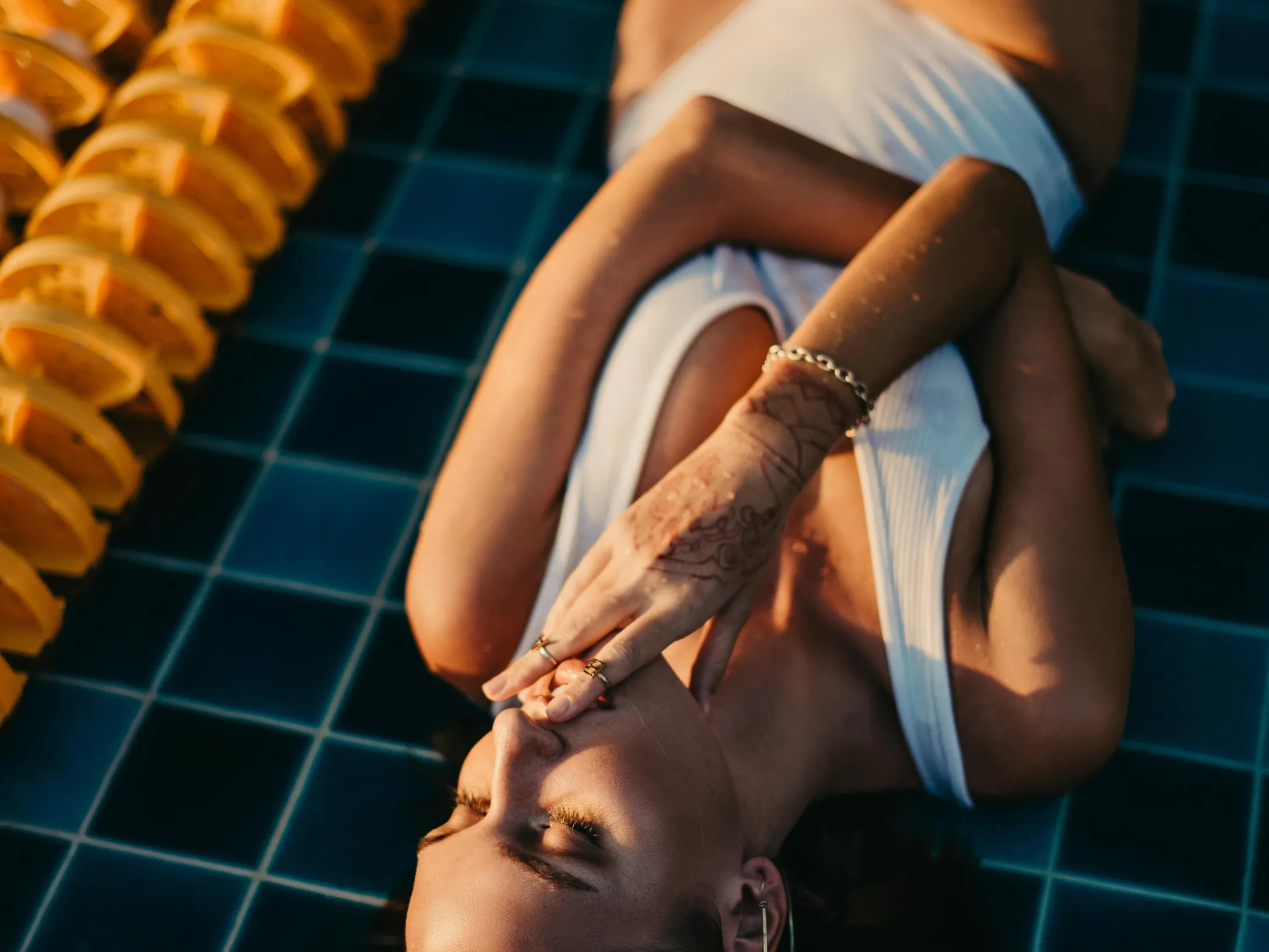 Person relaxing by a pool with pool salt nearby for melting ice.