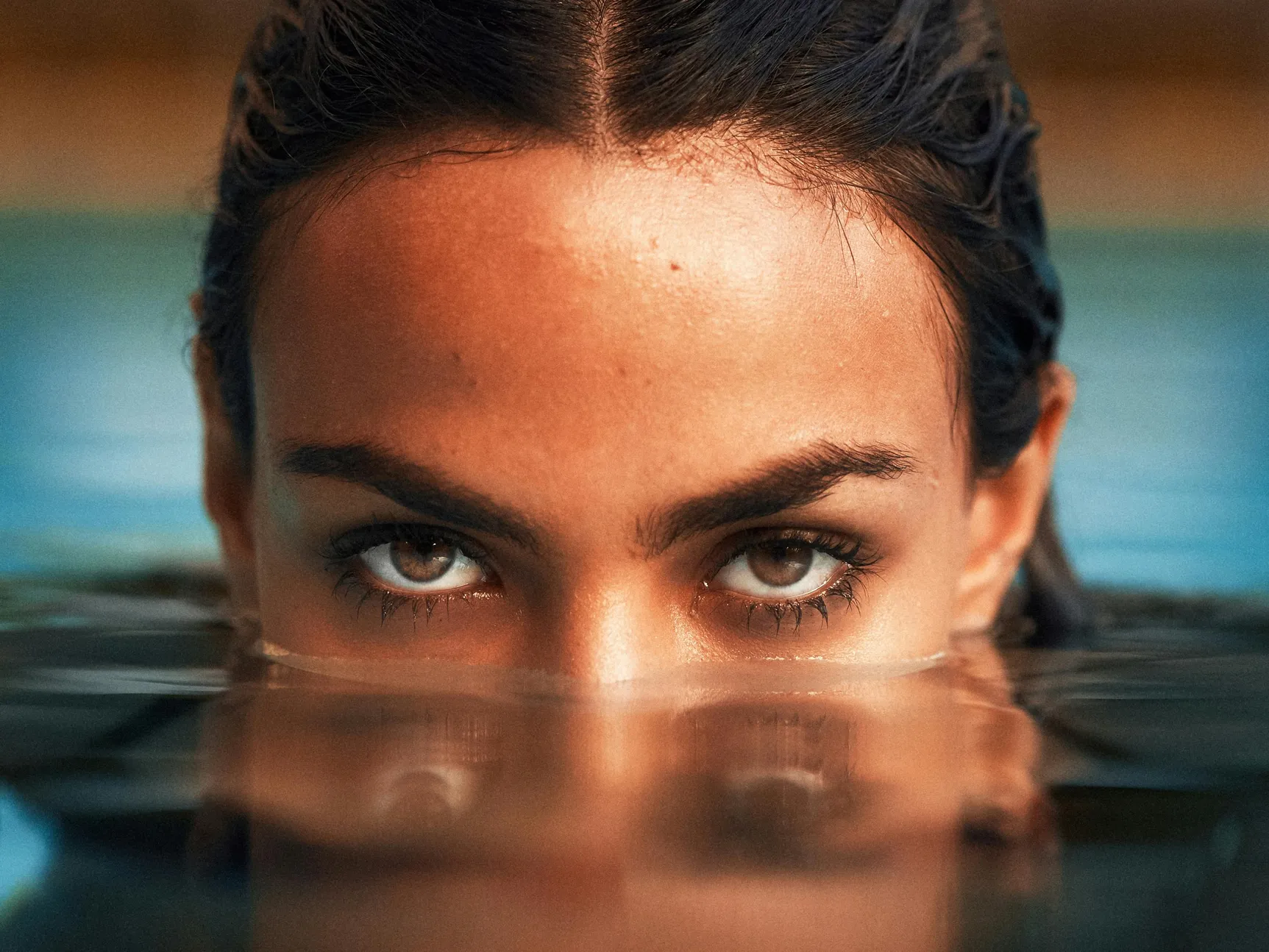 Close-up of a woman partially submerged in pool water, illustrating pool water conditions at night.