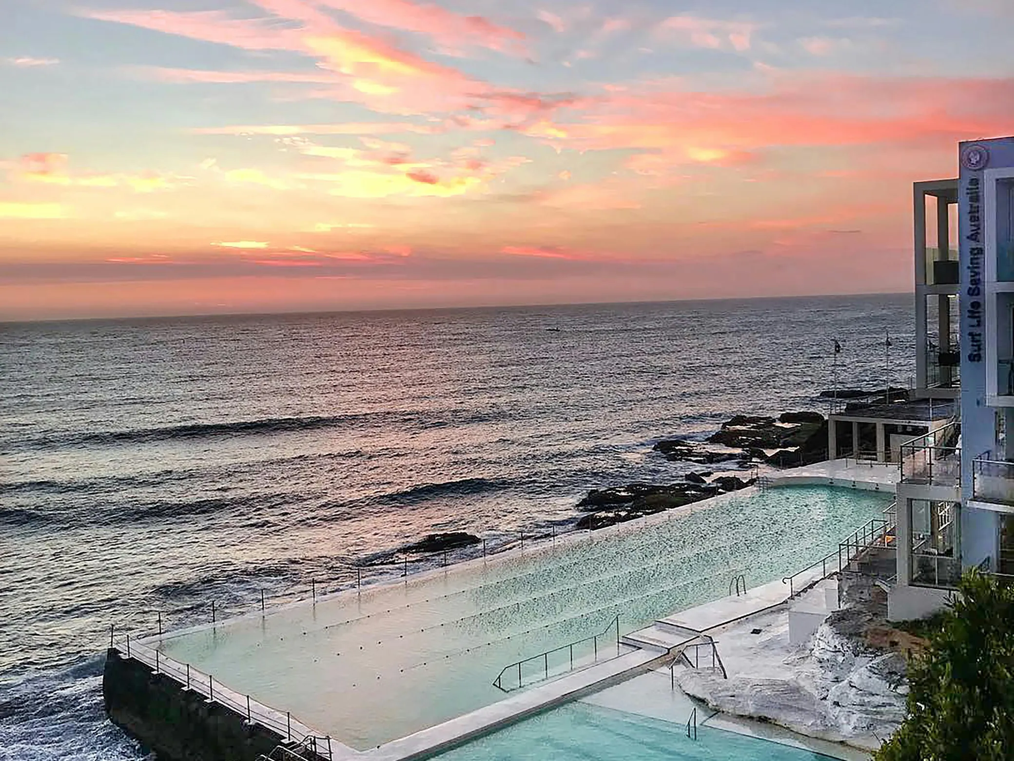 Sunset view of a swimming pool by the ocean, discussing using pool water to extinguish fires.