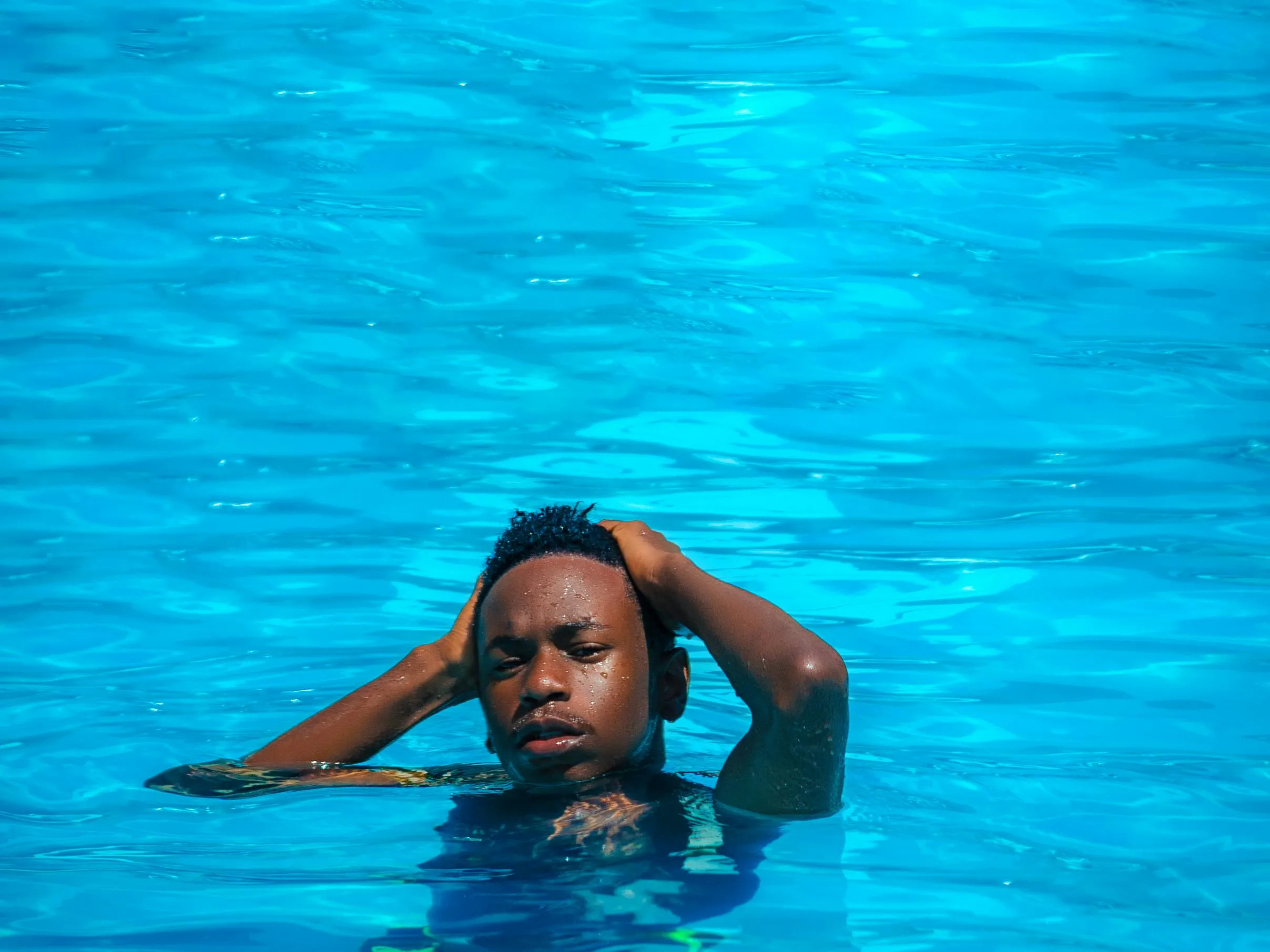 Child relaxing in a swimming pool, demonstrating the effects of pool water on fleas.