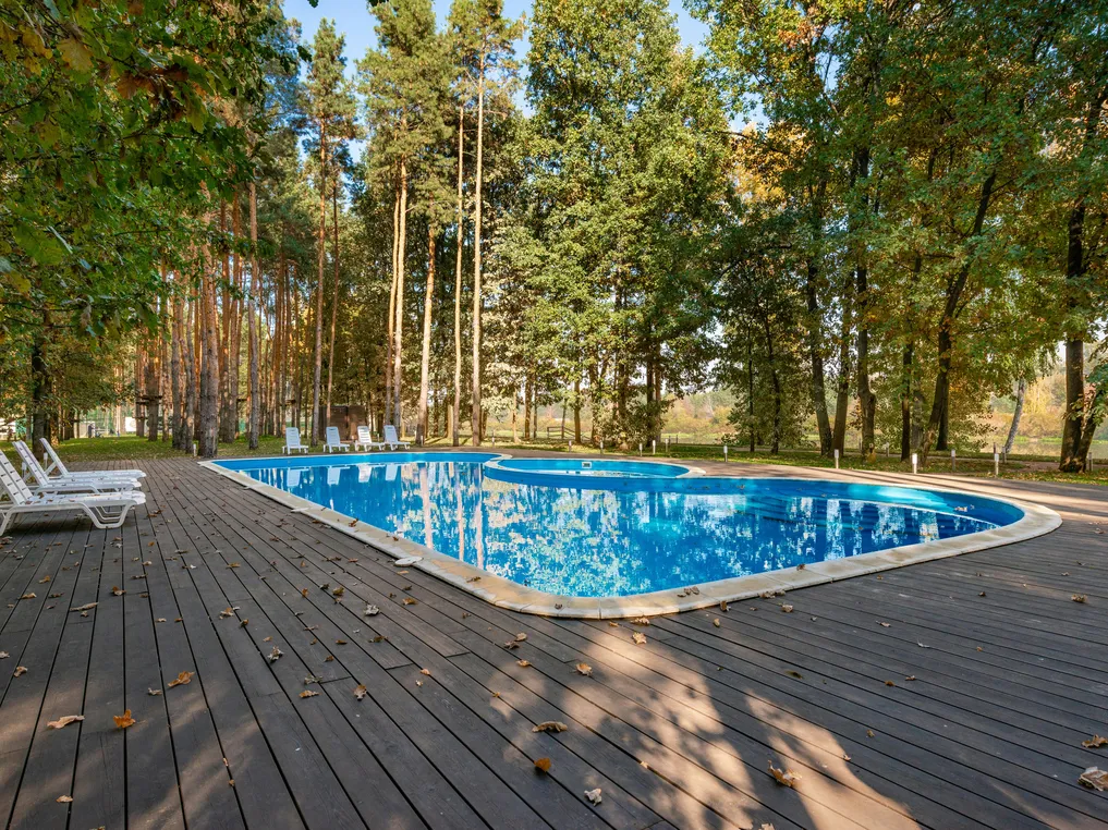 A pristine saltwater pool surrounded by trees, highlighting its clean and inviting appearance, relevant to saltwater pool sanitation.