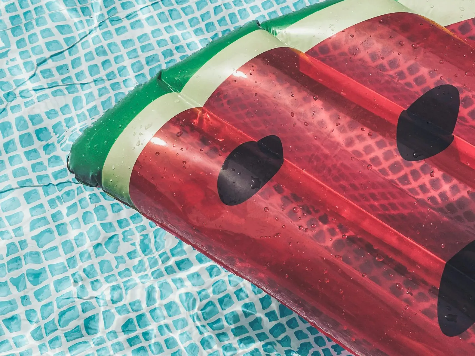Bright watermelon float in a stainless steel saltwater pool.