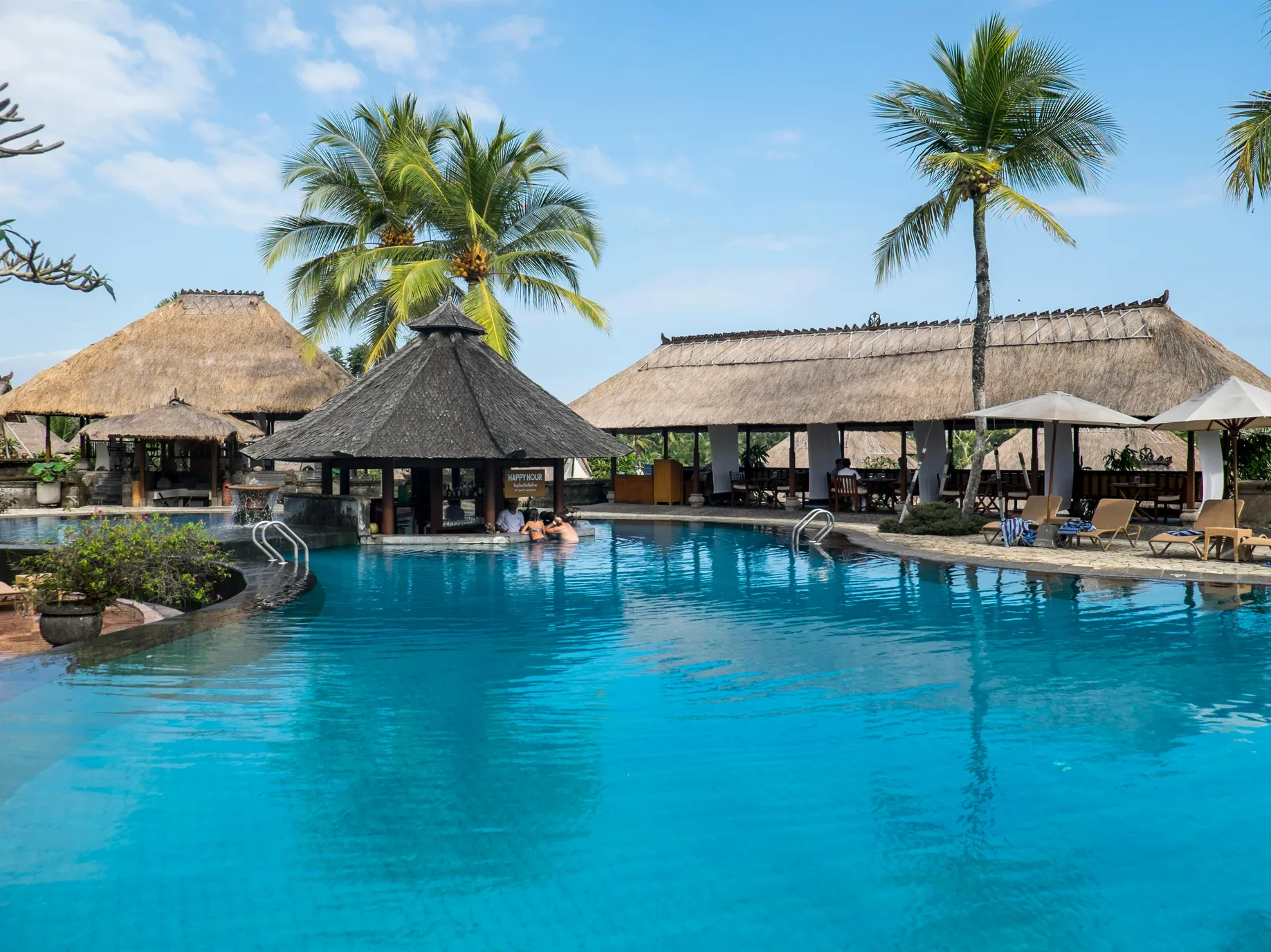 Beautiful pool area at South Point featuring palm trees and thatched roofs