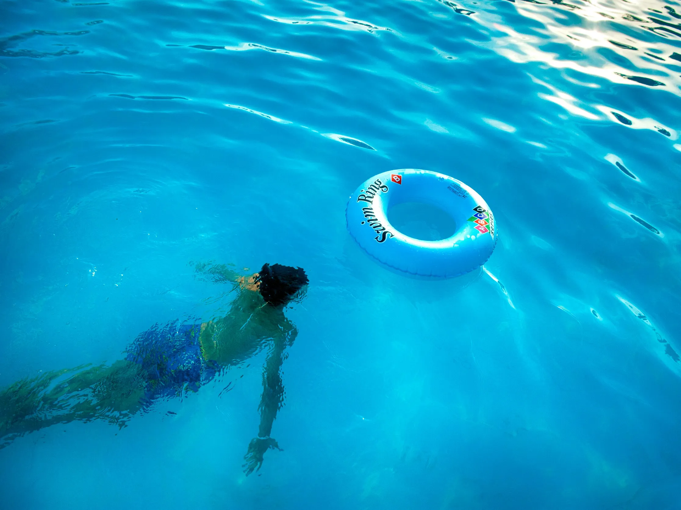 Person swimming in a pool with low chlorine levels, highlighting pool safety.