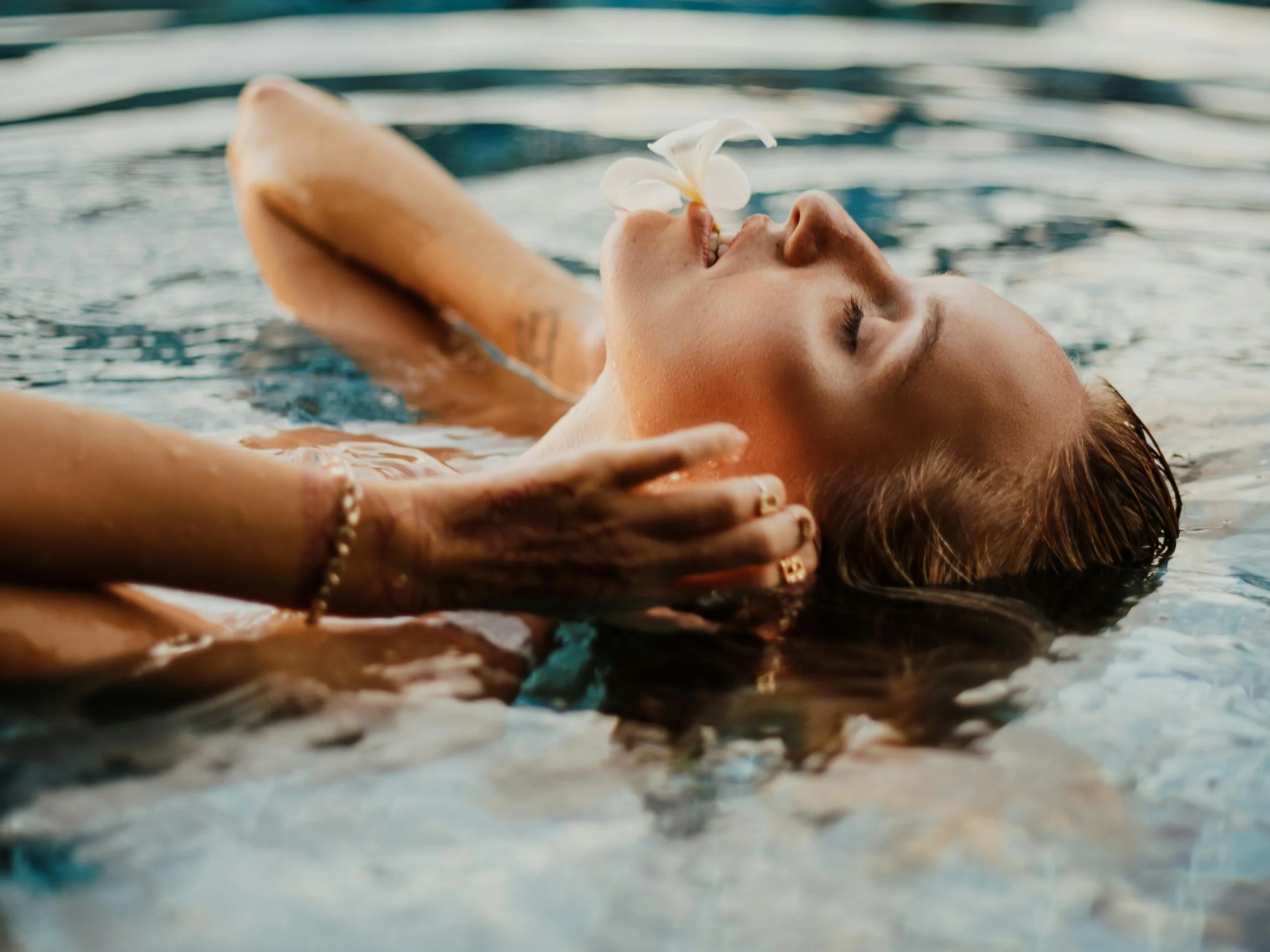 Image of a person relaxing in a pool, emphasizing the importance of water quality testing with pH, alkalinity, and sanitizer test strips.
