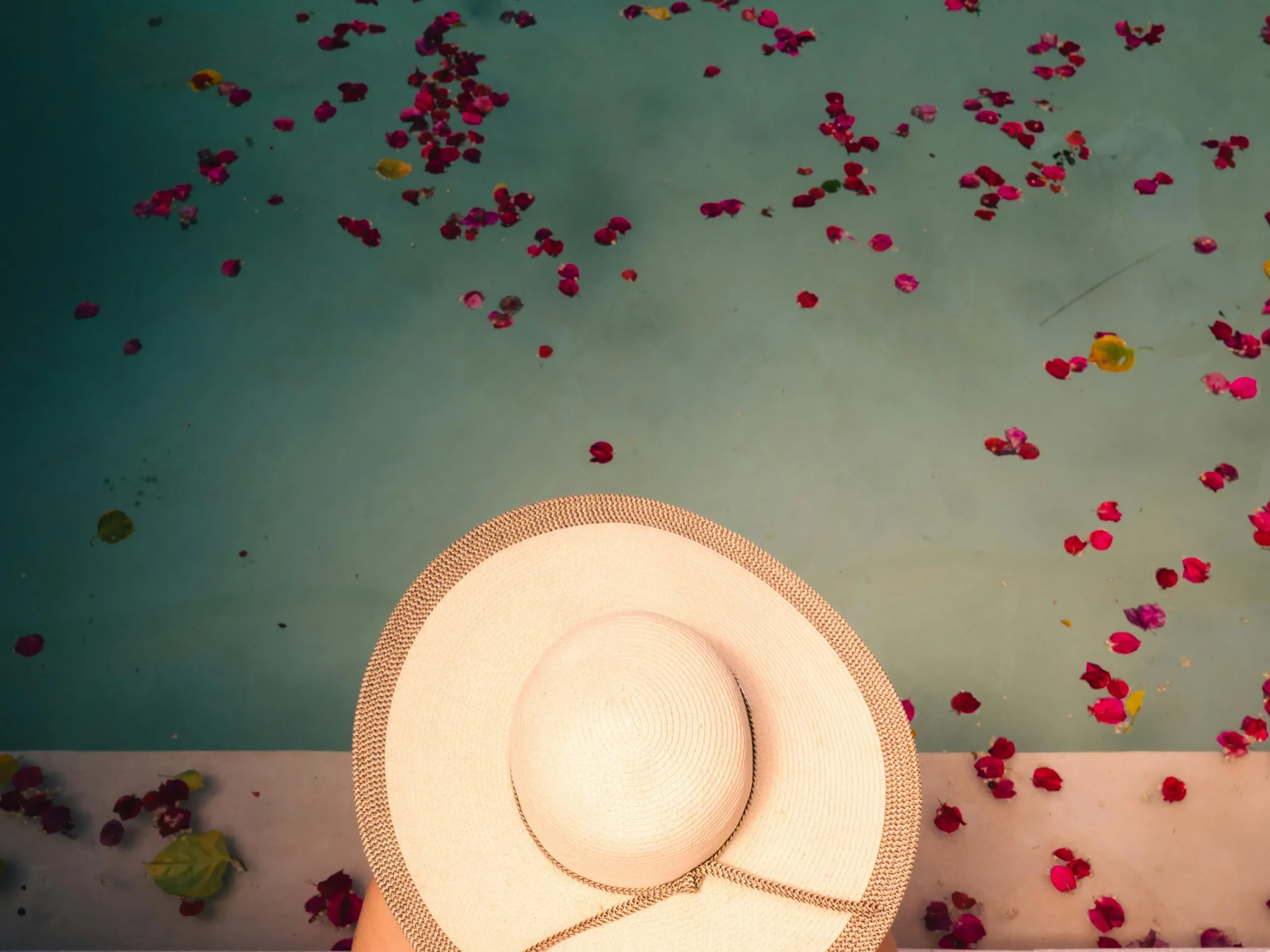 Aerial view of an unused pool with flower petals, highlighting potential mosquito breeding grounds related to unused pools.